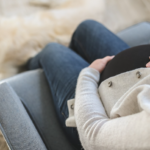 Vrouw met stress zittend op een stoel in de woonkamer.
